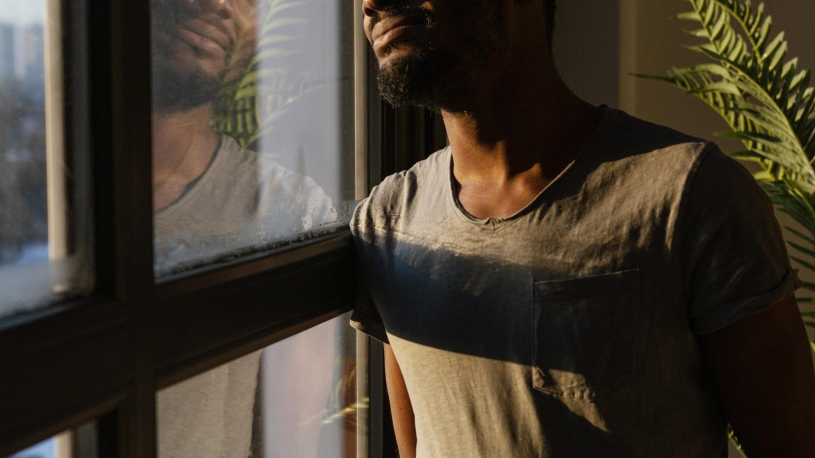 medium-shot-man-looking-out-window1